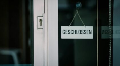 A close-up view of a 'Geschlossen' sign hanging on a door, indicating closure.