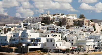 Stunning view of traditional white architecture in Naxos, Greece under a vibrant sky.