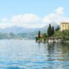 Picturesque view of Varenna, Italy with villa by Lake Como and mountain backdrop.