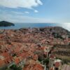 Explore the stunning aerial view of Dubrovnik's iconic Old Town and Adriatic Sea under a bright sky.