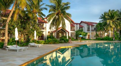 Explore a luxurious tropical resort featuring palm trees and an inviting poolside setting, perfect for leisure and relaxation.