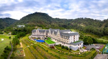 Scenic aerial photo of a luxury hotel surrounded by lush mountains.