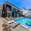 Contemporary villa with a private swimming pool and sun loungers, ideal for a luxury vacation.