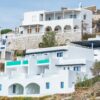 Whitewashed buildings on a Greek island showcasing traditional architecture with sea views.