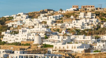 Scenic view of traditional white homes on a Greek island during daytime.