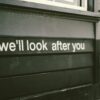 Close-up of a wooden facade with the positive message 'We'll look after you.'