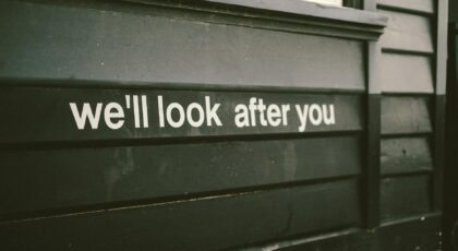 Close-up of a wooden facade with the positive message 'We'll look after you.'