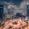 Stunning nighttime long exposure of Mexico City's bustling traffic circle with illuminated skyscrapers.