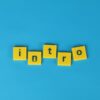 Yellow letter tiles spell 'intro' on a vibrant blue background, ideal for creative projects.