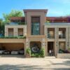 A stunning modern villa showcasing luxury and elegance with exotic cars and lush greenery.