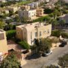 Aerial image showcasing modern villas and greenery in a luxury community in West Cairo, Egypt, perfect for real estate insights.