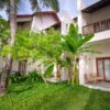 A lush garden with tropical plants at the exterior of a modern resort.