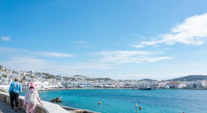 A beautiful day in Mykonos, Greece, showcasing the harbor and iconic white buildings.