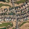 Aerial shot of luxury villas and golf course in Sheikh Zayed, Cairo, showcasing modern architecture and lush greenery.