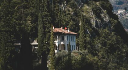 A serene Italian villa nestled in a lush, green forest setting, exuding tranquility and seclusion.