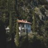 A serene Italian villa nestled in a lush, green forest setting, exuding tranquility and seclusion.