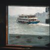 View of the Star Ferry crossing Victoria Harbour, iconic Hong Kong skyline in the background.