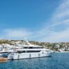 Elegant yachts moored at a picturesque harbor under clear blue skies in the Mediterranean.