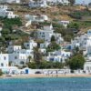 Beautiful Mykonos waterfront with iconic white houses and crystal-clear sea under bright summer skies.