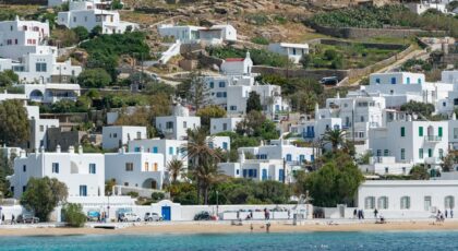 Beautiful Mykonos waterfront with iconic white houses and crystal-clear sea under bright summer skies.