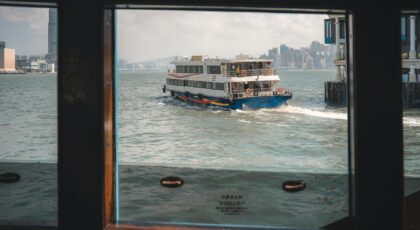 View of the Star Ferry crossing Victoria Harbour, iconic Hong Kong skyline in the background.
