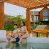 A couple enjoying drinks by the pool at a tropical resort, capturing a relaxing summer vacation vibe.